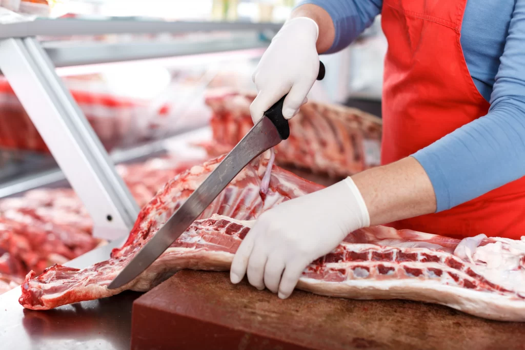 Butcher processing red meat.